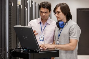 Two men working in a data center.